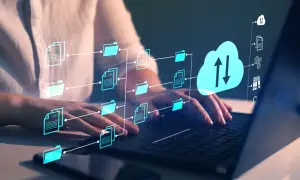 Ręce na klawiaturze laptopa, wizualizacja przepływu danych z ikonami folderów i dokumentów do chmury. Klient FTP zarządza plikami.
