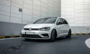 Vit Volkswagen Golf R, en bil som kan drabbas av 1.4 TSI-problem, kör på en asfalterad väg.