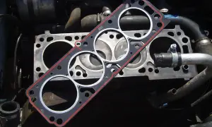 Nueva junta de culata lista para cambiar la vieja. El motor está desarmado, esperando la reparación.