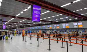Kasa odpraw na lotnisku Londyn Luton. Pasażerowie z bagażami czekają w kolejce do stanowisk linii lotniczych easyJet.