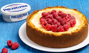 New York cheesecake con lamponi freschi, accanto a un vasetto di Philadelphia Original.