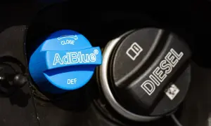 Le bouchon bleu indique "AdBlue", un liquide essentiel pour les moteurs diesel modernes. À côté, le bouchon noir est marqué "DIESEL".