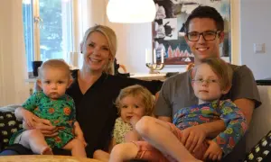 Famille souriante, avec deux enfants sur les genoux des parents. Le nom de famille suédois est Johansson.