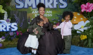 Rihanna z dziećmi na tle Smerfów. Mama tuli jedno dziecko, drugie stoi obok.