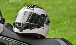 Biały kask motocyklowy z czarnymi i czerwonymi akcentami, gotowy do naprawy.
