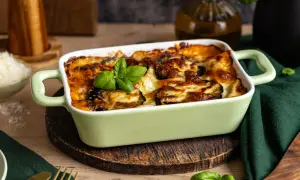 Herzhafte Auberginen Lasagne, goldbraun überbacken mit Käse und garniert mit frischem Basilikum. Ein Genuss für alle Sinne.