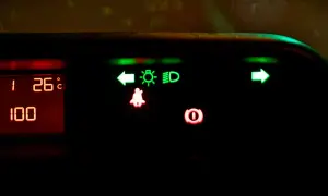 Na desce rozdzielczej świecą się zielone kontrolki: kierunkowskaz lewy, światła mijania, światła drogowe (high beam assist) i kierunkowskaz prawy. Czerwone kontrolki: pasy i hamulec.
