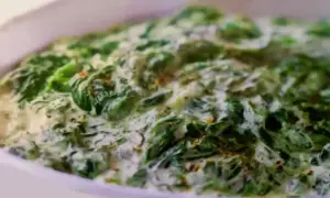 Un plat réconfortant d'épinards à la crème, parsemé d'épices, prêt à être dégusté.