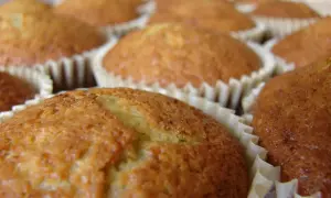 En närbild på flera gyllene bananmuffins utan socker i sina pappersformar. De ser saftiga och hembakade ut.