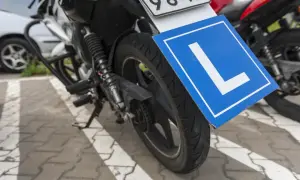 Motocykl z tabliczką "L" - symbol nauki jazdy, przygotowany do zdobycia prawa jazdy na motocykl.