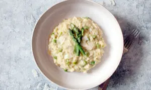 Cremiges Spargel-Erbsen-Risotto, garniert mit frischem Spargel und Parmesan. Ein köstliches Beispiel, was ist risotto.
