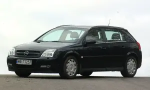 Czarny Opel Signum z czystymi żarówkami reflektorów, zaparkowany na zewnątrz.