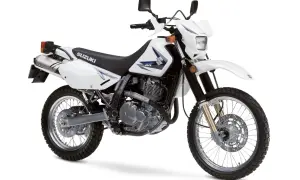Biały motocykl Suzuki DR650SE, idealny na lekkie enduro turystyczne, gotowy na przygodę.