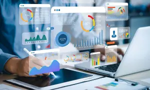 Big data scientist analizujący wykresy i dane na ekranach.