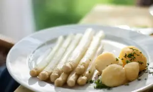 Ein Teller mit weißem Spargel und Salzkartoffeln, garniert mit Petersilie. Perfekt für einfache Spargel Rezepte.