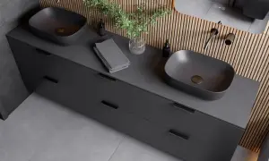 Nowoczesna łazienka z dwoma grafitowymi umywalkami nablatowymi i elegancką, **czarną armaturą**. Drewniana ściana dodaje ciepła.