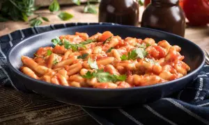 Piatto di pasta fagioli e cozze, un classico della cucina italiana, guarnito con prezzemolo fresco.