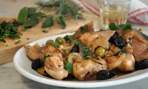 Piatto di coniglio alla cacciatora in bianco, con olive, cipolle e rosmarino. Un classico della cucina italiana.