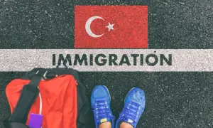 Bagaż i buty na tle flagi Turcji i napisu IMMIGRATION. Czy Turcja jest w Schengen?