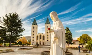 Pomnik Matki Bożej z różą przed kościołem. To miejsce objawień, nie tylko święte miasto.
