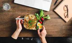 Pausa pranzo salutare con couscous, ceci, uova e verdure. La normativa sulla pausa pranzo incoraggia pasti equilibrati per il benessere lavorativo.