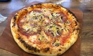 Pyszna pizza z pieczarkami i salami, idealnie wypieczona. Dowodzi, ile nagrzewa się kamień do pizzy, by uzyskać taki efekt.