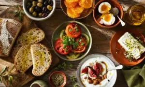 Un petit-déjeuner méditerranéen avec pain, olives, tomates, œufs, fromage, yaourt et fruits. Parfait pour savoir que cuisiner cette semaine.