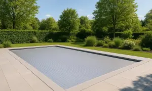 En elegant pool med ett modernt, grått poolskydd. En vacker trädgård med gröna häckar och träd ramar in poolen, perfekt för att bygga eget poolskydd.