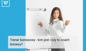 Młoda kobieta, trener biznesu, pisze na tablicy.