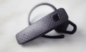 Czarna słuchawka Bluetooth z teksturą kółek. Dowiedz się, jak sparować słuchawki z telefonem.
