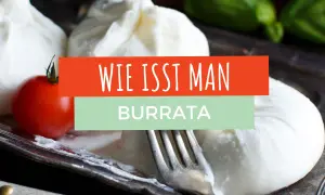 Frische Burrata mit Tomate und Basilikum auf einem Teller. Ein Gabel liegt daneben. Der Text "Wie isst man Burrata" ist eingeblendet.