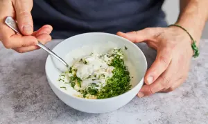 Ein cremiger Knoblauchdip mit frischer Petersilie wird zubereitet, perfekt als Beilage zu Flammlachs.