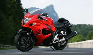 Czerwono-czarny motocykl Suzuki Hayabusa 1300 na drodze, z górami w tle.