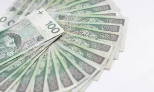 Stos stuzłotowych banknotów, ułożonych wachlarzowo. Idealne na świadczenie urlopowe, by odpocząć i cieszyć się wolnym czasem.