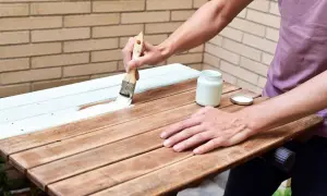 Aplicando imprimación para madera barnizada a una mesa de madera.