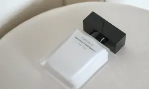 Elegancka butelka perfum Narciso Rodriguez Pure Musc for her, z czarną nakrętką, na jasnym tle.