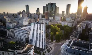 Widok na miasto z nowoczesnym budynkiem Holiday Inn Twarda w centrum. W tle wieżowce i zieleń.
