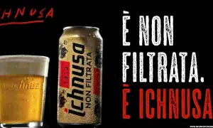 A glass of Ichnusa beer and a can of Ichnusa Non Filtrata beer on a black background.