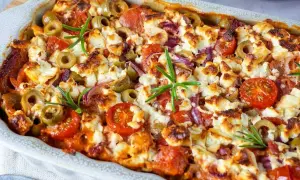 Herzhafter Kritharaki Auflauf mit Feta, Oliven, Tomaten und Rosmarin, goldbraun gebacken.