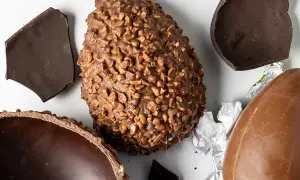 Uova di Pasqua al cioccolato, una con nocciole, altre rotte. Un assaggio delle loro origine.