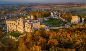 Zamek w Ogrodzieńcu, majestatyczna ruina na skale, otoczona jesiennymi barwami lasów i malowniczym krajobrazem Jury.