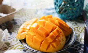 Pokrojone w kostkę mango na talerzyku, idealne na zdrową przekąskę. Sprawdź, ile ma mango kcal!
