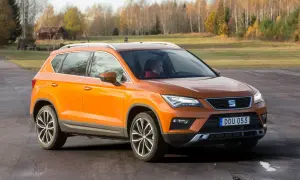 Orange Seat Ateca på en grusväg, redo för ett test. En förare syns bakom ratten.