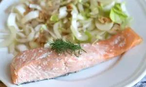 Un délicieux pavé de saumon rose, garni d'aneth frais, servi avec une salade croquante de fenouil et d'oignons.
