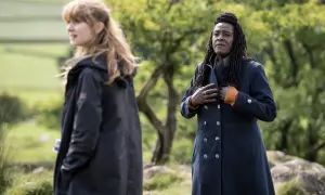 Två kvinnor i mörka rockar utomhus, en med blont hår, den andra med dreadlocks. Scen från engelska kriminalserier.