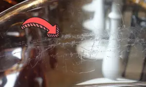Flèche rouge indiquant des traces de peinture à enlever sur du verre.