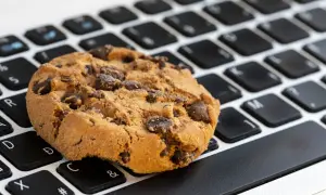 Ciasteczko z kawałkami czekolady na klawiaturze. Zastanawiasz się, jak wyłączyć ciasteczka w przeglądarce?