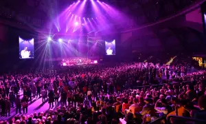 Wielki koncert w Stadionie Wrocław. Tłumy fanów, scena z orkiestrą i ekranami, na których widać dyrygenta.