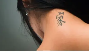 Mały tatuaż na karku, symbolizujący dom i rodzinę, dyskretnie ozdabia skórę.