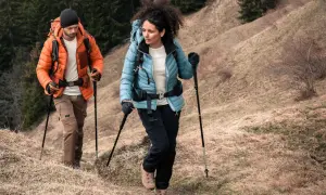 Para trekking w górach, ważne są odpowiednie **końcówki do kijków w góry**. Para turystów w odzieży outdoorowej pokonuje górski szlak.